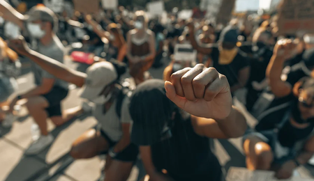 A group of people kneeling and raising their fists